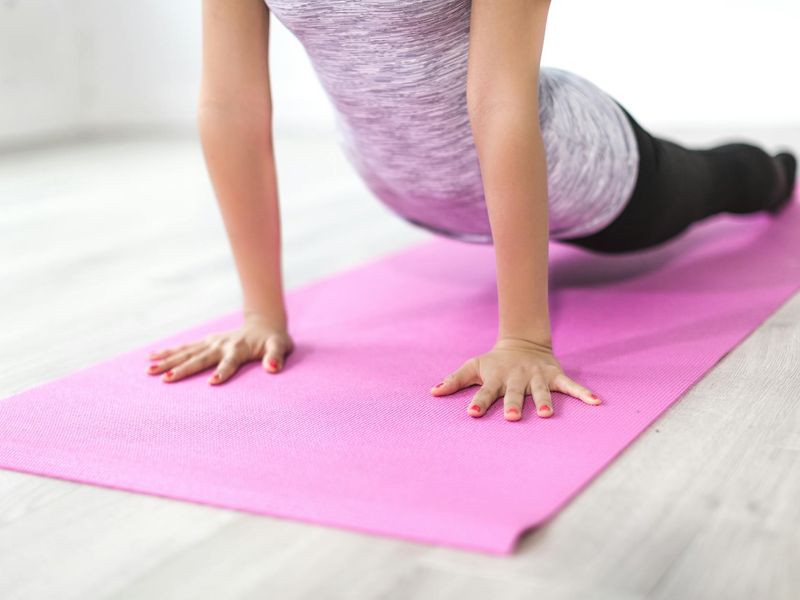 Person performing a smooth yoga transition in a dark studio.