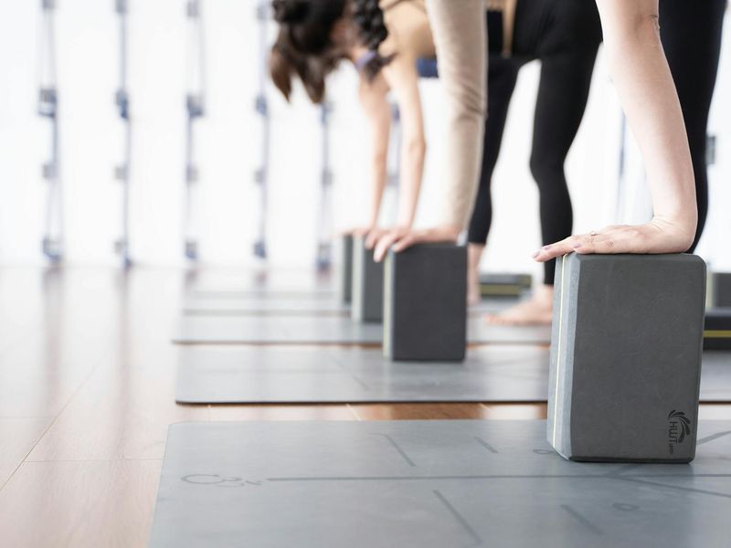 Yoga mat and blocks in a minimalist dark studio.